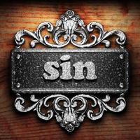 sin word of iron on wooden background photo