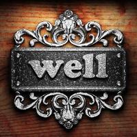 well word of iron on wooden background photo