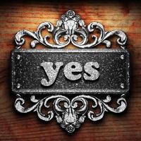 yes word of iron on wooden background photo