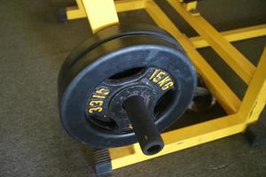 Editorial image of a 15 KG black barbell plate for exercising in the gym photo