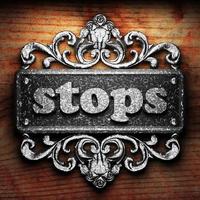 stops word of iron on wooden background photo