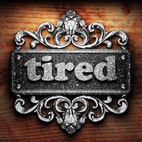 tired word of iron on wooden background photo