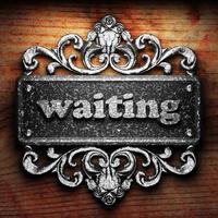 waiting word of iron on wooden background photo