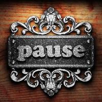 pause word of iron on wooden background photo