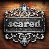 scared word of iron on wooden background photo