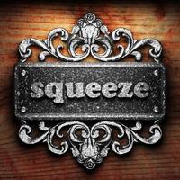 squeeze word of iron on wooden background photo