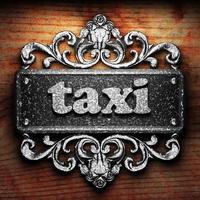 taxi word of iron on wooden background photo