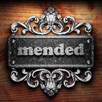 mended word of iron on wooden background photo