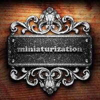 miniaturization word of iron on wooden background photo