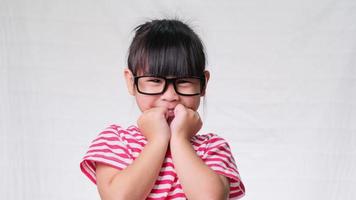 Cute little girl wearing glasses, she nice-looking, charming and enjoying a good mood on white background in studio.