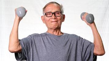 asiatisk senior man tränar med hantlar hemma. hälsosam livsstil video