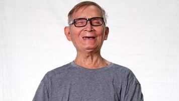 o velho asiático sorriu alegremente mostrando seus dentes perdidos e segurando dentaduras na mão. conceito de saúde e atendimento odontológico video