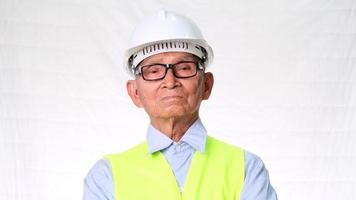 Confident senior engineering architect wearing vest and helmet on white background in studio. video