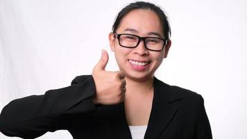 femme d'affaires asiatique heureuse debout avec le geste du pouce levé sur fond blanc en studio video