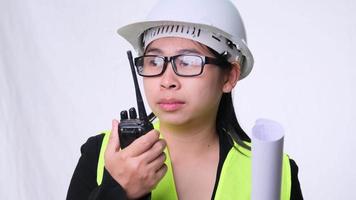 engenheira civil em um capacete segurando planos de construção e usando walkie-talkie e conversar com outros funcionários em um fundo branco no estúdio.
