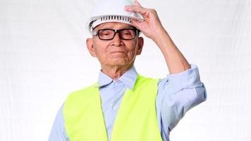 Confident senior engineering architect wearing vest and helmet on white background in studio. video