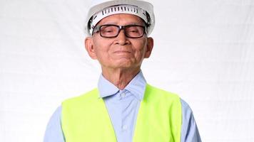 Senior architect engineering builder wearing safety vest and helmet suffers wrist aches from hard work on a white background in a studio. video