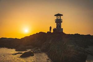 faro de luz de khao lak, hermosa puesta de sol en la playa de nang thong, khao lak, tailandia. puesta de sol tropical colorida con cielo nublado. patrones de textura de arena en la playa, mar de andaman phang nga tailandia foto