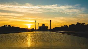 Songkhla Central Mosque in day to night with colorful skies at sunset and the lights of the mosque and reflections in the water in landmark landscape concept photo