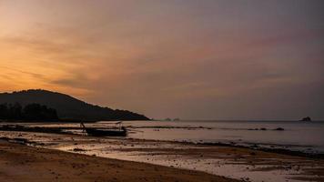 small fishing boat on the beach in the evening photo