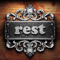 rest word of iron on wooden background photo