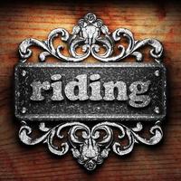 riding word of iron on wooden background photo