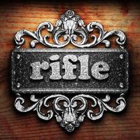rifle word of iron on wooden background photo