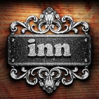 inn word of iron on wooden background photo