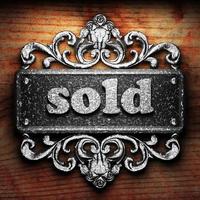 sold word of iron on wooden background photo