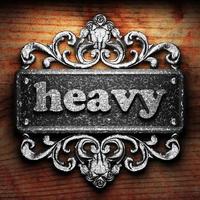 heavy word of iron on wooden background photo