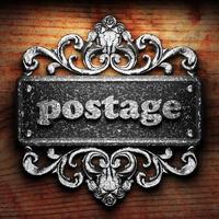 postage word of iron on wooden background photo