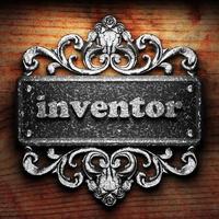 inventor word of iron on wooden background photo