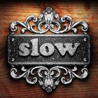 slow word of iron on wooden background photo