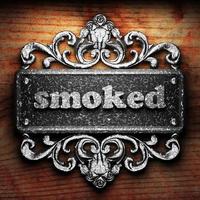 smoked word of iron on wooden background photo