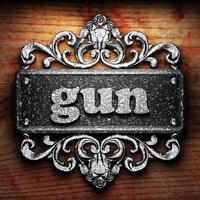 gun word of iron on wooden background photo