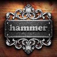 hammer word of iron on wooden background photo
