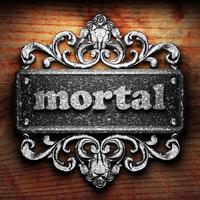 mortal word of iron on wooden background photo