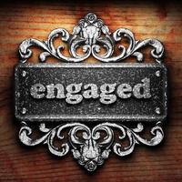 engaged word of iron on wooden background photo