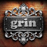 grin word of iron on wooden background photo