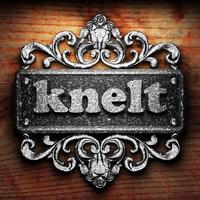 knelt word of iron on wooden background photo