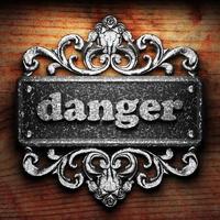 danger word of iron on wooden background photo
