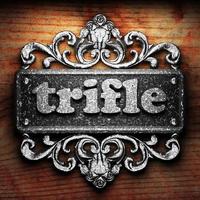 trifle word of iron on wooden background photo