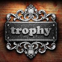 trophy word of iron on wooden background photo