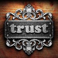 trust word of iron on wooden background photo
