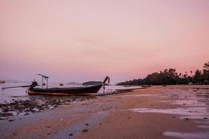 small fishing boat on the beach in the evening photo