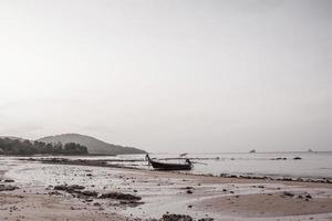 small fishing boat on the beach in the evening photo