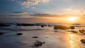 sunset landscape on the beach rocks in foreground photo