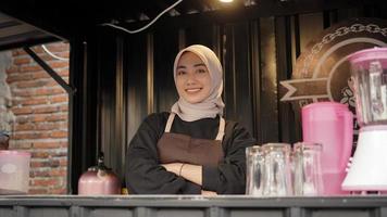 beautiful asian waitress with arms looks cool guarding cafe booth container photo