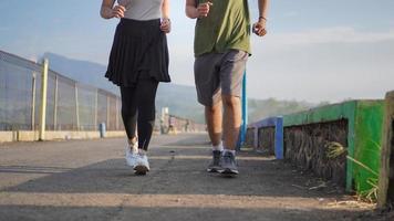 Close up side view photo of young asian couple legs running