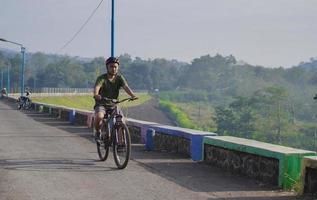 young asian man ride bicycle in the morning photo